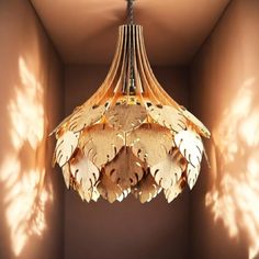 a chandelier made out of wooden leaves hanging from the ceiling in a room