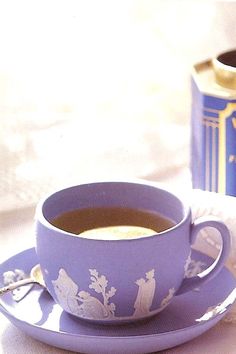 a cup of coffee sitting on top of a saucer next to a box of tea