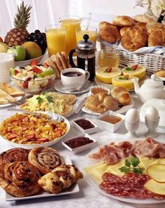 a table filled with lots of different types of breakfast foods and condiments on it