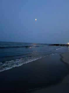 the moon is setting over the water at the beach