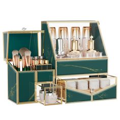 an open green and gold makeup case filled with brushes, containers and other cosmetics items