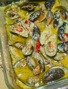 a casserole dish with mussels and shrimp in it on a table