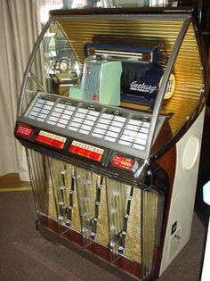 an old fashioned juicing machine sitting on top of a carpeted floor next to a window