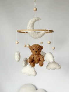 a teddy bear is hanging from a mobile