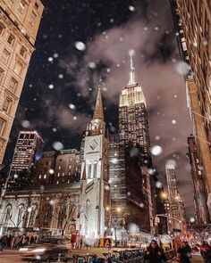 people are standing in the snow near tall buildings