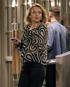 a woman standing in front of a door holding a cell phone