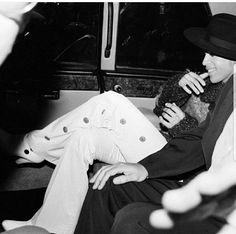 black and white photograph of two people sitting next to each other on a bus together