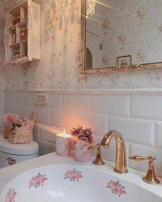 a white sink sitting under a bathroom mirror next to a toilet