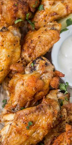 chicken wings with ranch sauce on the side and garnished with cilantro