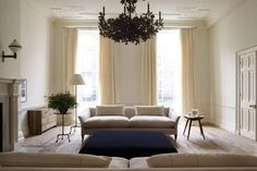 a living room filled with furniture and a chandelier