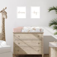 a baby's room with two giraffes on the wall