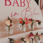 there are many vases with flowers in them on the wall next to a sign that says baby in blue