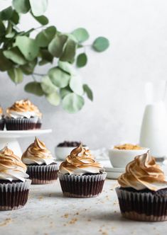 several cupcakes with frosting on them sitting on a table