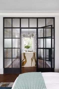 the bedroom is decorated in white and black with glass doors that lead to an outdoor bathtub