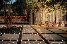 an outdoor wedding with string lights and trees