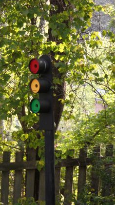 a traffic light sitting next to a wooden fence