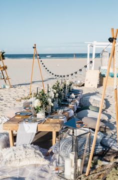 a table set up on the beach for an outdoor dinner