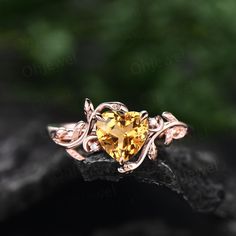 a heart shaped yellow topazte ring with leaves on the sides and an intricate band around it