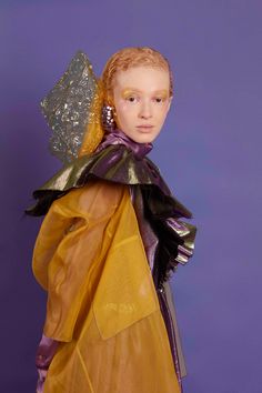 a mannequin dressed in yellow and purple with an angel wings on her head