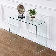 a glass table with a plant on top and a small vase sitting next to it