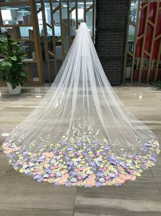 a wedding veil with flowers on the floor in front of a building entrance and entryway