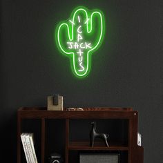 a neon sign that says jack and is next to a book shelf