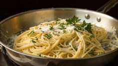 a pan filled with pasta and parsley on top of a stove