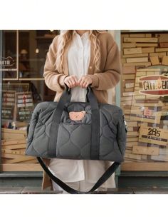 a woman carrying a gray bag with a monkey on it