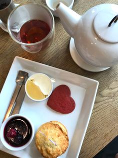 a white plate topped with pastries next to a cup of tea