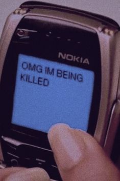 a person holding a cell phone with the text omg im being killed on it