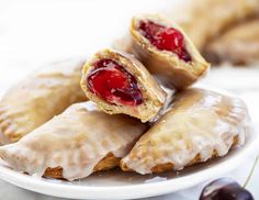 several pastries on a white plate with cherries