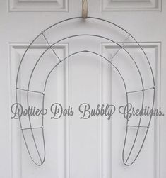 a metal horseshoe door hanger with the words do it's bushby creations