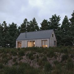 a small house sitting on top of a hill next to some tall grass and trees