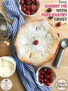 a cherry pie with puff pastry crust and cherries in bowls on a wooden table