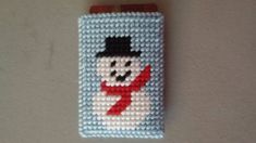 a cross stitch cell phone case with a snowman on it