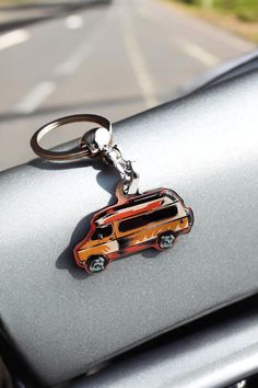 a car keychain with an orange van on it's front end is shown