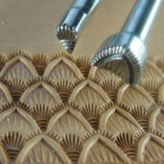 two metal tools sitting on top of a brown tablecloth covered in intricately designed designs