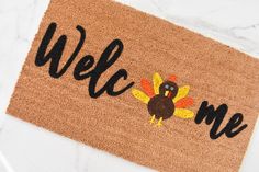 a welcome mat with a turkey on it that says,'welcome me'in black lettering