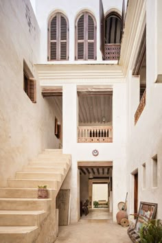 the interior of an old building with stairs and potted plants