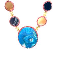 This exquisite necklace showcases a harmonious blend of vibrant gemstones, each radiating its unique charm. The centerpiece is a striking large blue stone, perfectly complemented by an array of smaller multicolored stones, all set in delicate gold settings. Ideal for adding a pop of color and elegance to any outfit. Luxury Round Multicolor Necklaces, Luxury Multicolor Round Necklace, Luxury Multicolor Round Necklaces, Luxury Multicolor Natural Gemstones, Luxury Multicolor Necklace With Gemstone Accents, Luxury Multicolor Gemstone Necklaces, Luxury Multicolor Necklaces With Gemstone Accents, Luxury Multicolor Necklaces With Natural Stones, Luxury Multicolor Natural Stone Necklaces