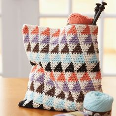 a crocheted bag sitting on top of a table next to a ball of yarn