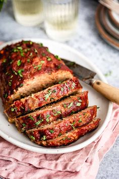 sliced meatloaf on a plate with a knife