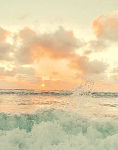 a person riding a surfboard on top of a wave in the ocean at sunset