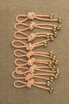 several pieces of rope with gold beads on them sitting on top of a brown table cloth