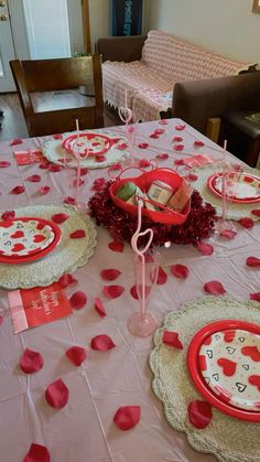 a table set for valentine's day with plates, cups and napkins on it