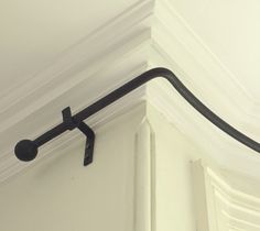 a close up of a metal hook on the wall above a window sill in a room