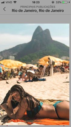 a woman laying on top of a sandy beach