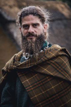 a man with a long beard wearing a cape