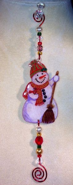 a glass ornament with a snowman holding a broom on it's side