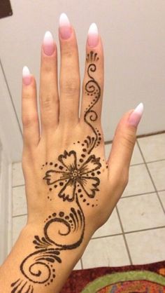 a woman's hand with henna tattoos on it